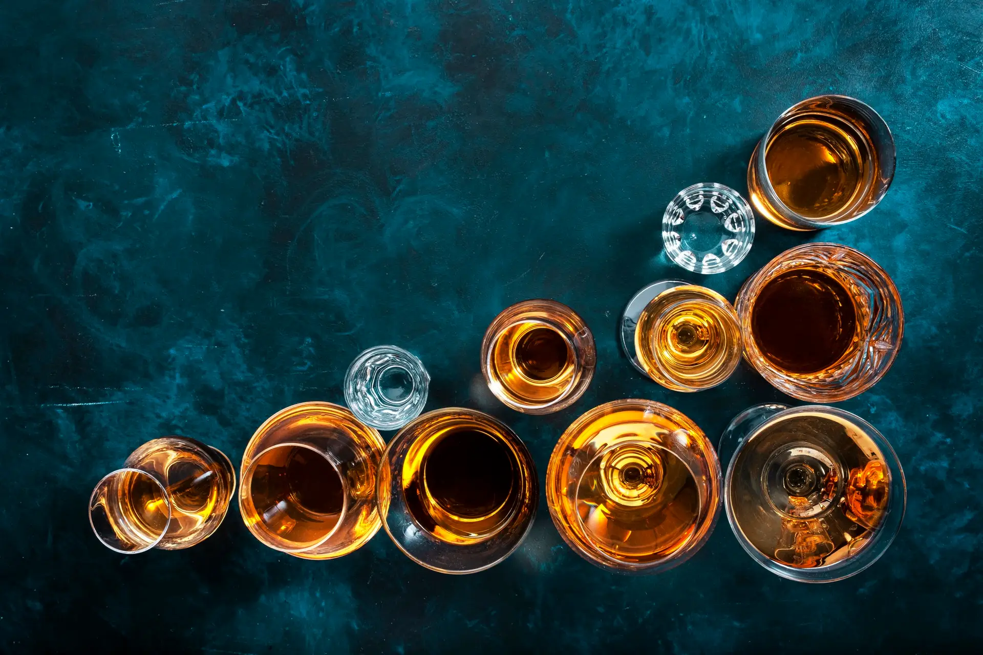 hard liquors, spirits and distillates set in glasses: cognac, scotch, whiskey and other.